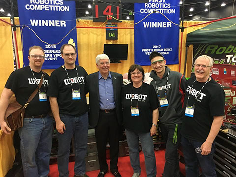 Four of our mentors and one student  posing  with  Michigan's  Governor  Rick  Snyder  in  our  pit.