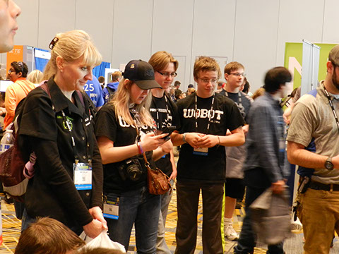 Students watching a spider styled walking /jumping robot being displayed at the Innovation fair.