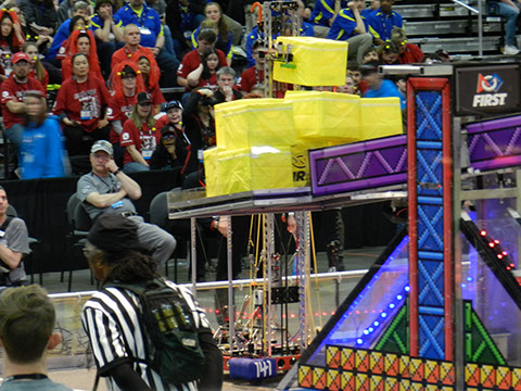 Our robot putting a cube on the taller scale to keep it on our side.