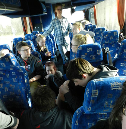 The students playing games on the bus.