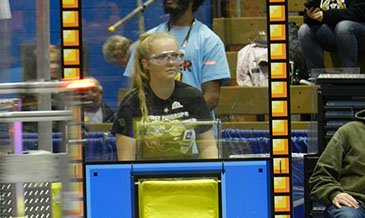 Maddison, human player, watching and waiting for a robot to come and get a block.