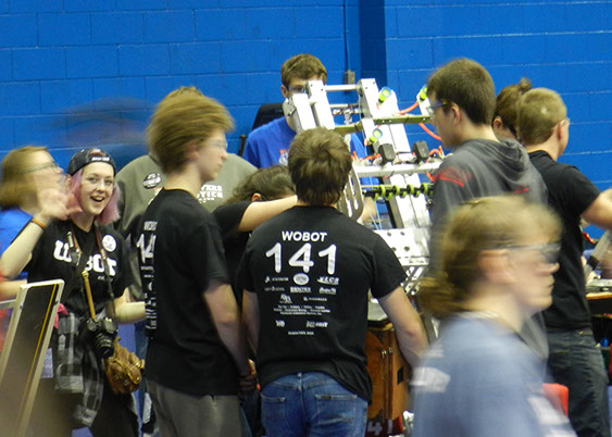 Our drive team waiting for another match while our student photographer waves hi to another team photographer