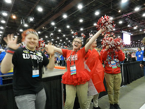 A student making friends with a team from Canada, who came over and helped cheer for our team for one match